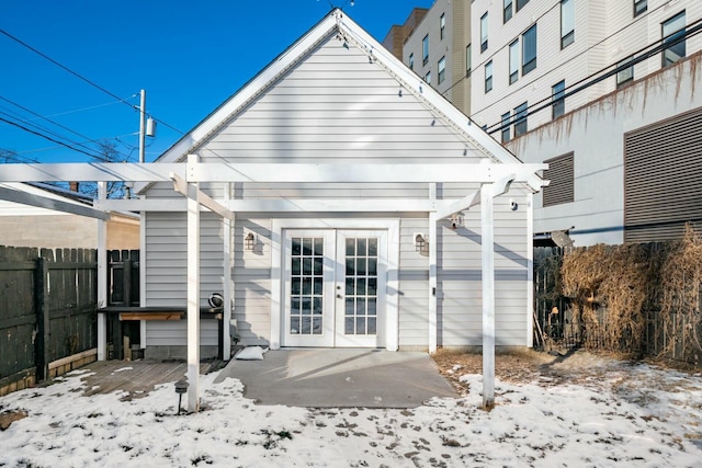 snow covered rear of property with french doors