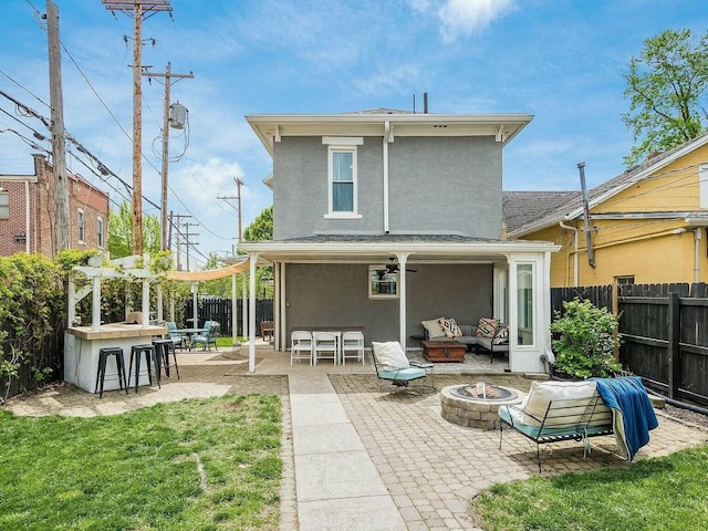 rear view of house featuring an outdoor living space with a fire pit, a patio, and exterior bar