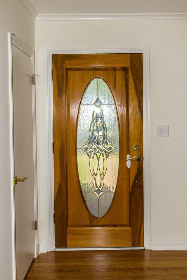 doorway to outside with dark hardwood / wood-style floors and ornamental molding