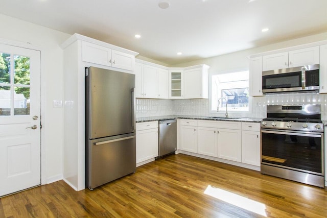 kitchen featuring appliances with stainless steel finishes, a wealth of natural light, white cabinetry, and dark hardwood / wood-style floors