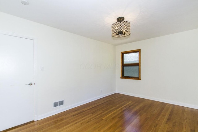 unfurnished room with dark hardwood / wood-style flooring