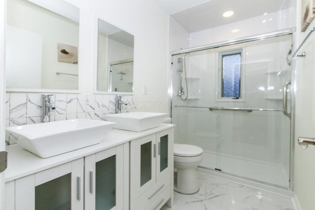 bathroom featuring toilet, tile walls, a shower with shower door, and vanity