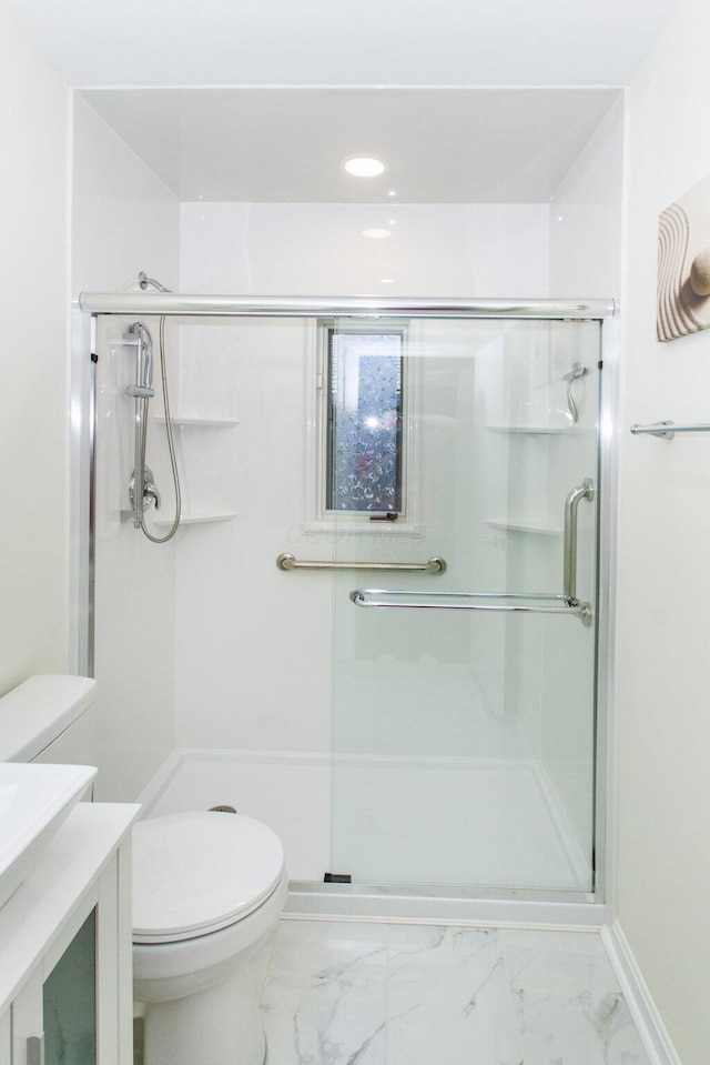 bathroom with toilet, vanity, and an enclosed shower