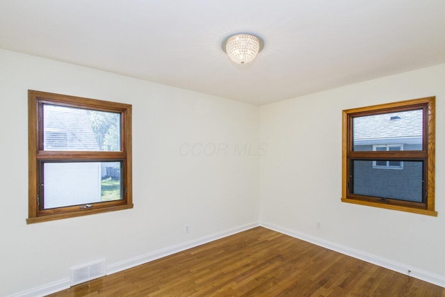 unfurnished room with hardwood / wood-style flooring