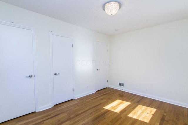 unfurnished bedroom featuring dark hardwood / wood-style flooring