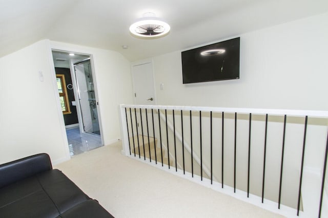 corridor with light colored carpet and vaulted ceiling