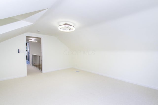 bonus room featuring vaulted ceiling and carpet