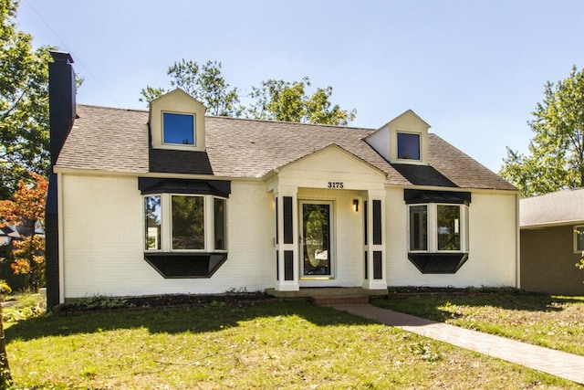 cape cod home with a front lawn