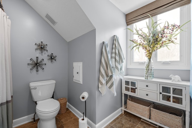 bathroom with lofted ceiling and toilet