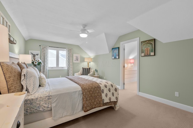 bedroom with ceiling fan, lofted ceiling, ensuite bath, and light carpet