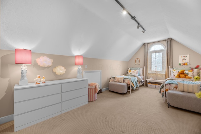 carpeted bedroom featuring lofted ceiling and track lighting