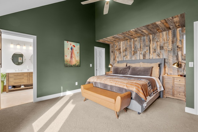 bedroom featuring sink, ceiling fan, a towering ceiling, connected bathroom, and carpet floors