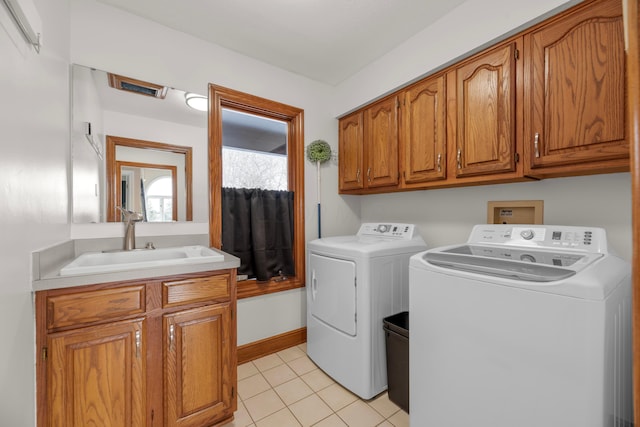 washroom with sink, cabinets, washer and dryer, and light tile patterned flooring