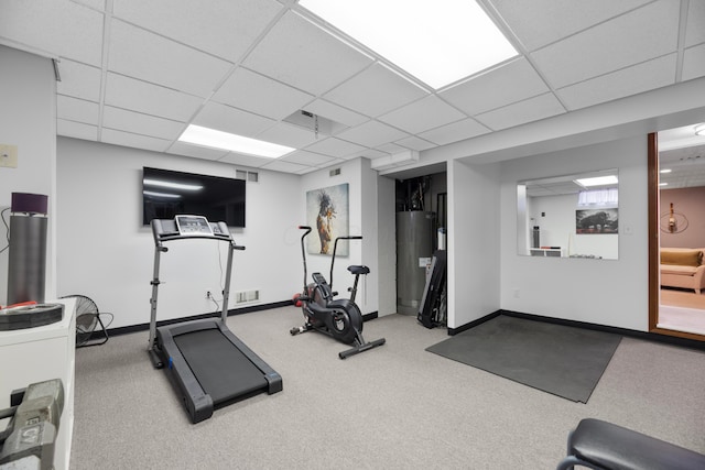 workout room featuring a paneled ceiling and water heater