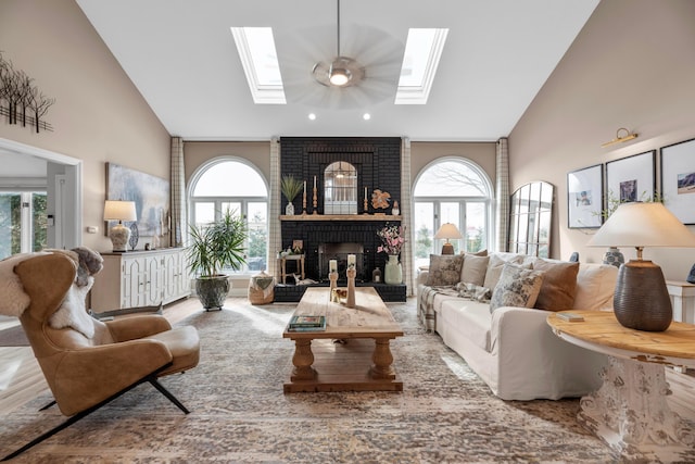 living room with a healthy amount of sunlight, a fireplace, a skylight, and high vaulted ceiling