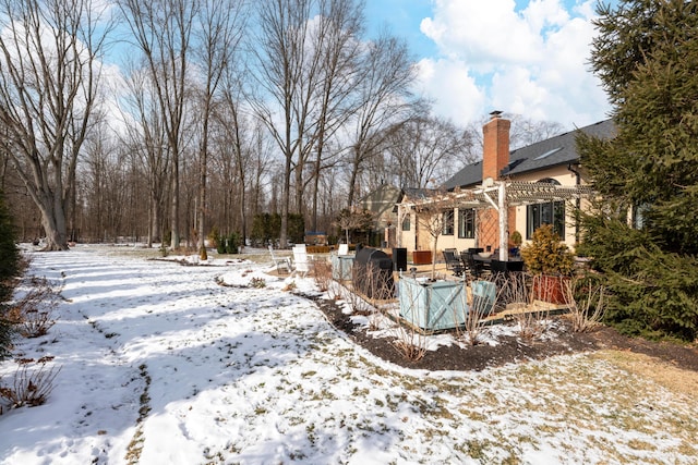 snowy yard featuring a pergola