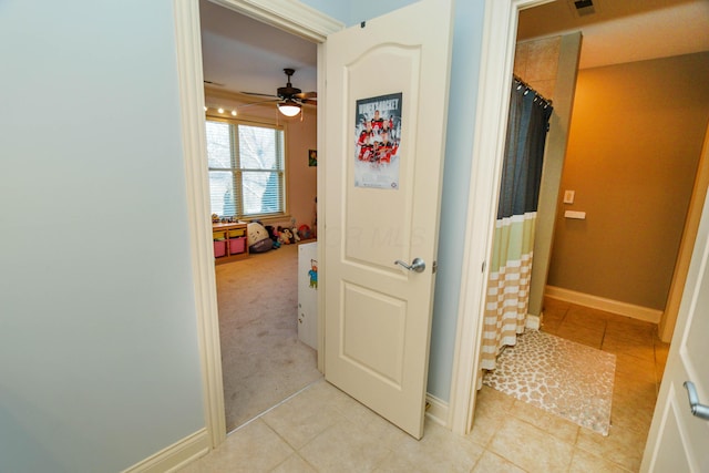 bathroom with ceiling fan and tile patterned floors