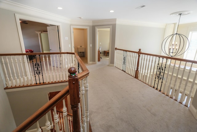 corridor with crown molding, a chandelier, and carpet flooring