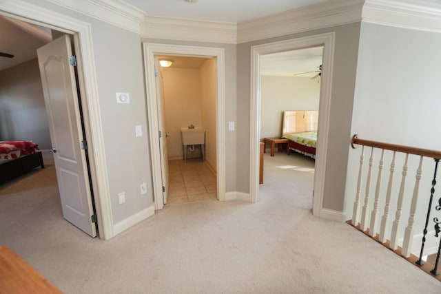 corridor with sink, ornamental molding, and light carpet