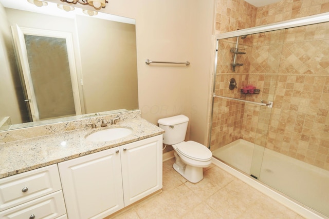 bathroom featuring toilet, tile patterned flooring, walk in shower, and vanity