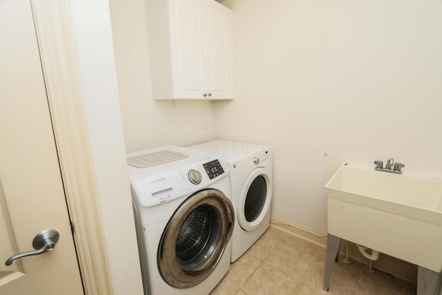 laundry area featuring cabinets, separate washer and dryer, and sink