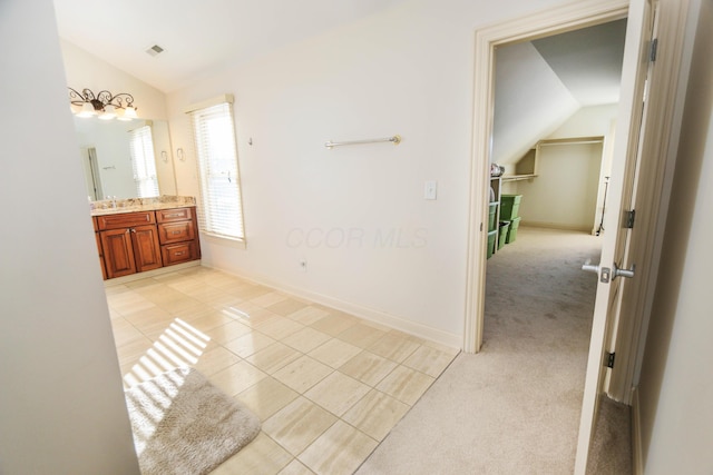 bathroom featuring vanity, vaulted ceiling, and tile patterned floors