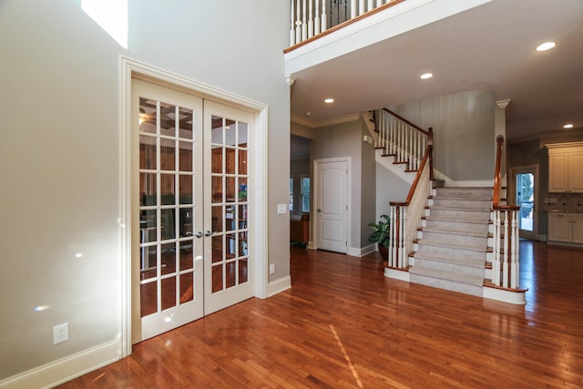 entrance foyer with dark hardwood / wood-style floors, ornamental molding, and french doors