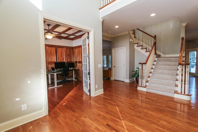 interior space with ceiling fan, dark hardwood / wood-style floors, beamed ceiling, coffered ceiling, and ornamental molding