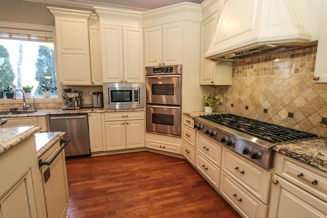 kitchen with appliances with stainless steel finishes, sink, backsplash, and custom range hood