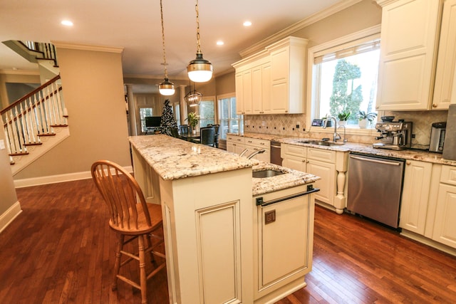 kitchen with dishwasher, an island with sink, sink, hanging light fixtures, and a breakfast bar