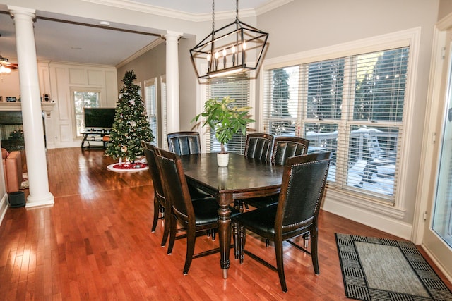 dining space featuring crown molding, wood-type flooring, and decorative columns