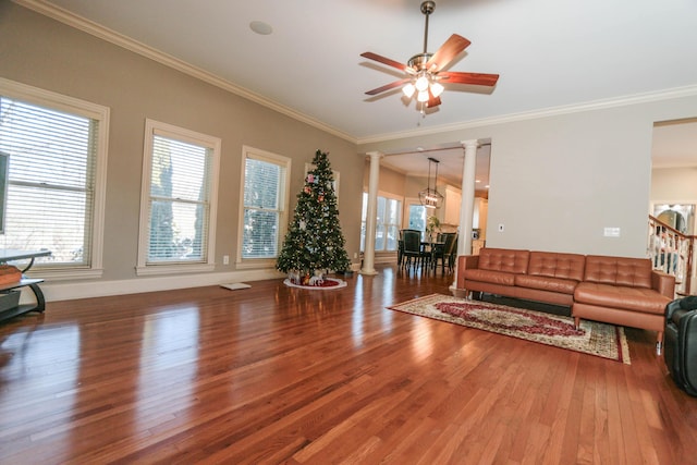 living room featuring ornate columns, ornamental molding, and wood-type flooring