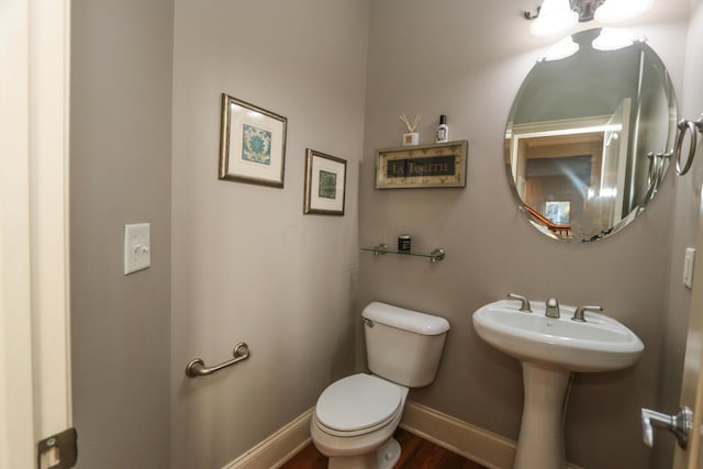 bathroom featuring toilet, sink, and hardwood / wood-style floors