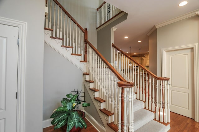 stairs with crown molding and wood-type flooring