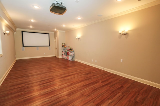 cinema room with ornamental molding and dark hardwood / wood-style floors