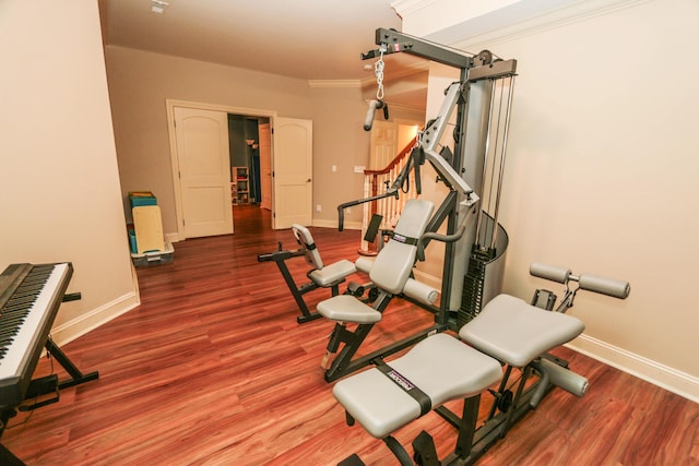 exercise area with wood-type flooring and ornamental molding