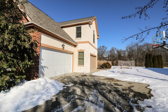 view of snowy exterior with a garage