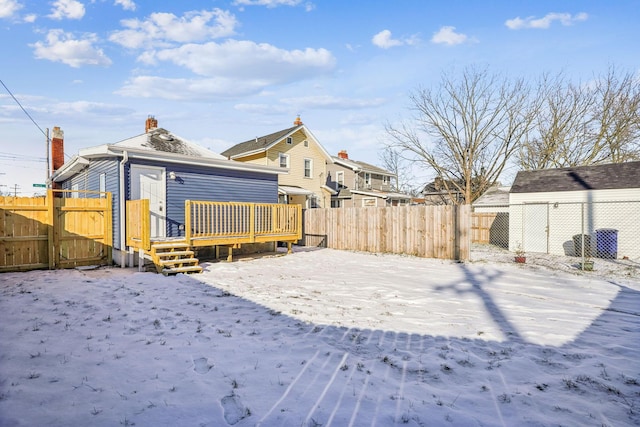 yard layered in snow with a deck