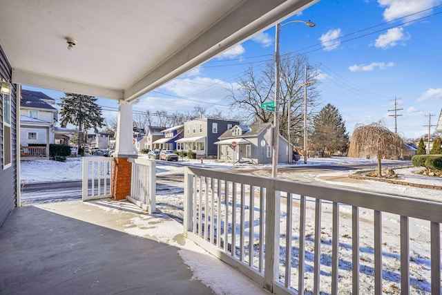 snow covered patio with a porch