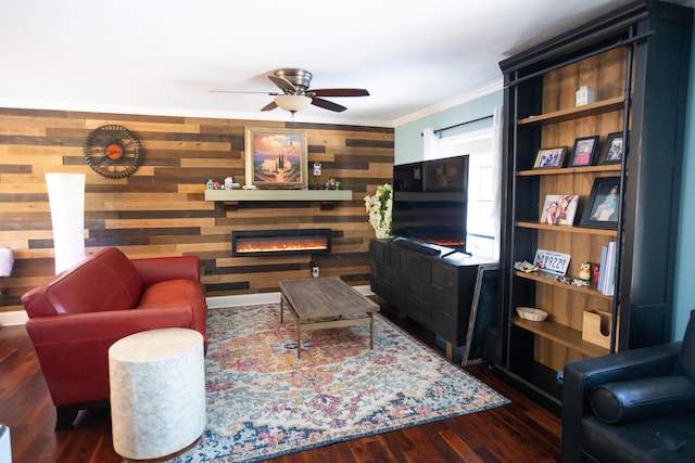 living room with a fireplace, wooden walls, dark hardwood / wood-style floors, ceiling fan, and crown molding