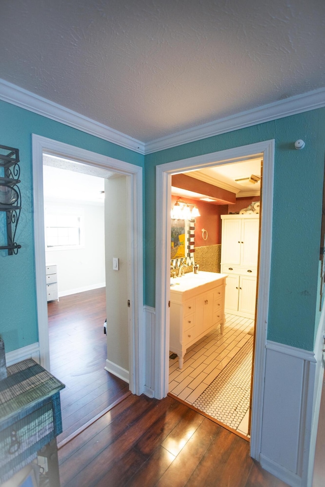 hallway with dark wood-type flooring and crown molding