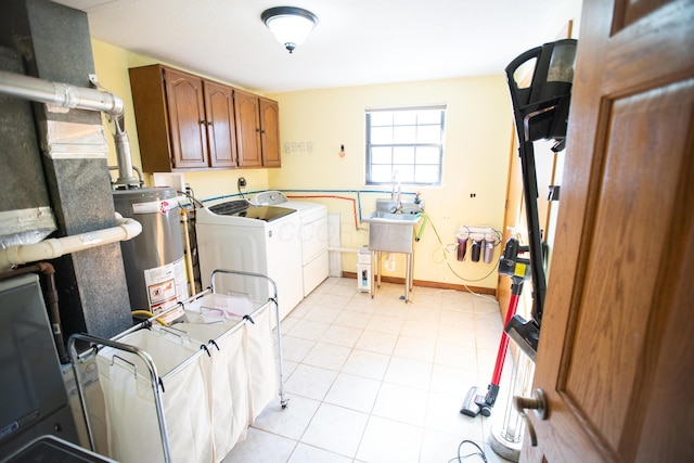 laundry area featuring washer and dryer, sink, light tile patterned flooring, water heater, and cabinets