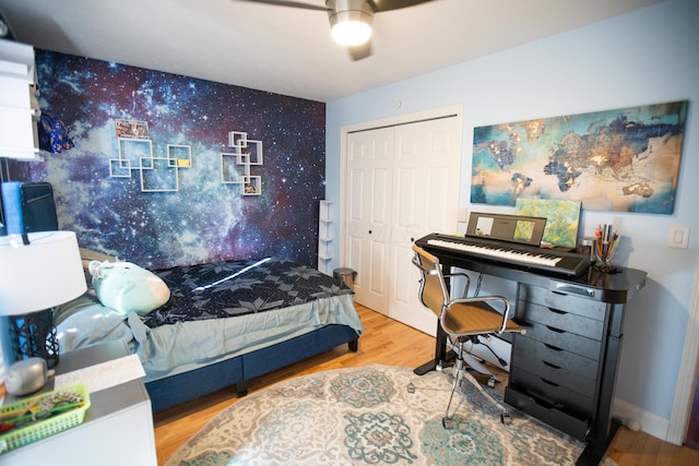 bedroom featuring ceiling fan, a closet, and light hardwood / wood-style floors