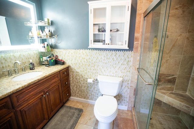 bathroom featuring a shower with shower door, vanity, tile patterned floors, and toilet