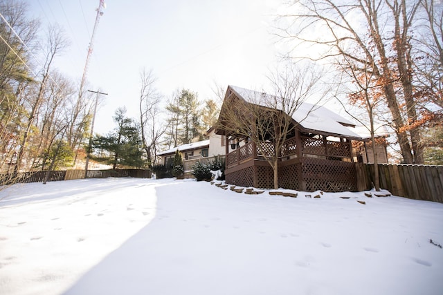 yard covered in snow with a deck