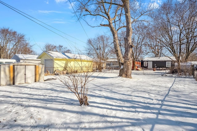 yard layered in snow with a storage shed