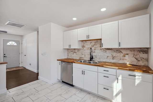 kitchen with backsplash, wooden counters, stainless steel dishwasher, sink, and white cabinets