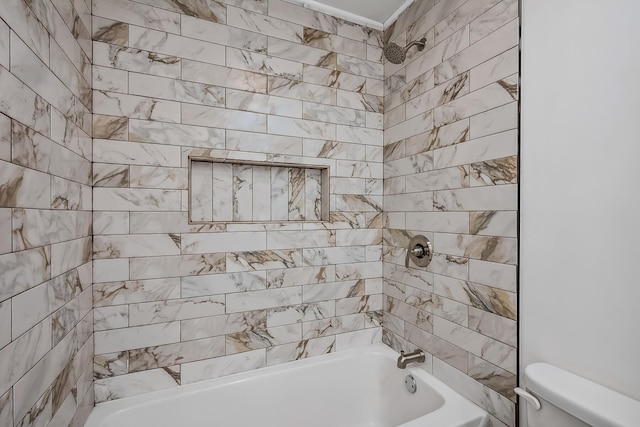 bathroom with toilet and tiled shower / bath