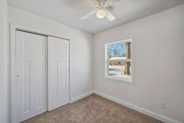 unfurnished bedroom featuring ceiling fan, a closet, and carpet flooring