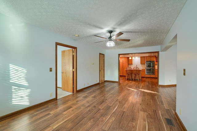 unfurnished living room with dark hardwood / wood-style floors and ceiling fan